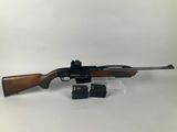 a rifle with a wooden barrel and scope on a white background