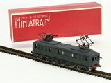 un petit train qui se trouve sur les rails, à côté d'une boîte