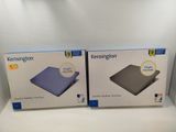 two boxed boxes of a laptop computer sitting on top of a white shelf