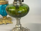 three different colored glass vases on a table