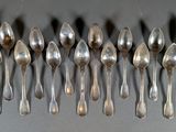 six silver spoons are arranged in a row on a table