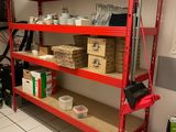 une étagère rouge sur laquelle sont posées des boîtes, dans une pièce