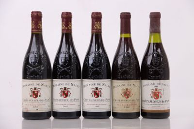 quatre bouteilles de vin sont alignées sur une surface blanche