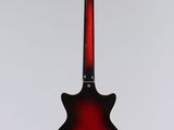 a red guitar hanging from a string on a white background