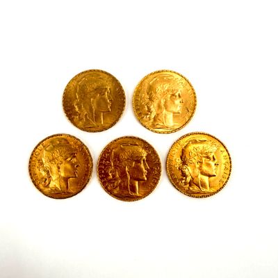 four different types of gold coins sitting on top of a white surface