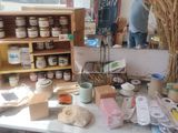 a table with a bunch of items on it and a man standing in the background