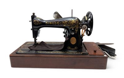 a black and gold sewing machine sitting on a wooden stand