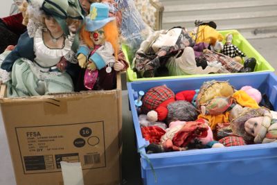 deux boîtes contenant des poupées, posées par terre