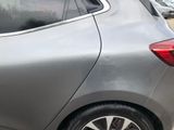 a silver car parked in a parking lot with other cars in the background