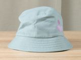 a blue hat with a pink flower on it on a wooden table