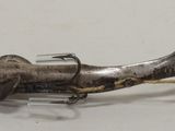 a metal object with a fish on it on a white surface