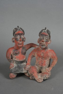 two figurines of a man and a woman sitting next to each other