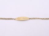 a gold chain bracelet with a small oval engraved on it