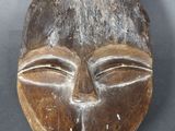 gros plan d'un masque en bois sur une surface grise