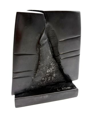 une sculpture noire représentant une montagne posée sur un livre