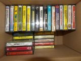 a cardboard box filled with many different types of cassettes