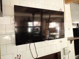 un téléviseur à écran plat fixé au mur au-dessus d'une cheminée
