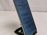 a close up of a cell phone on a stand on a white surface
