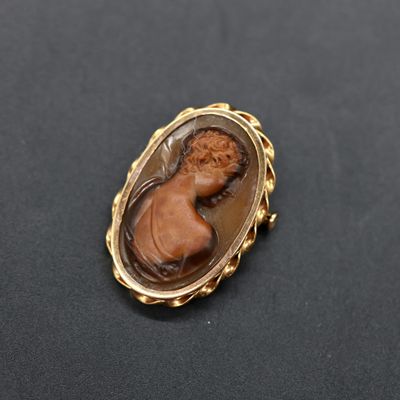 an image of a broochle of a woman in a gold frame