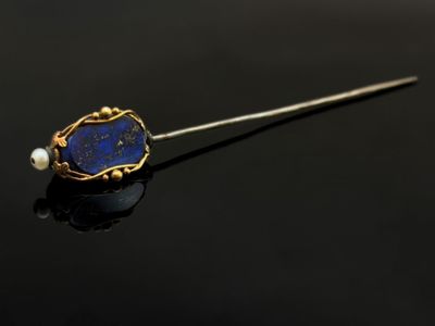 une broche de revers ornée d'une pierre de revers et de perles