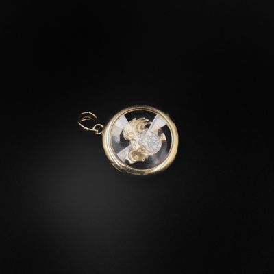 une image représentant un pendentif en or avec un cheval au centre
