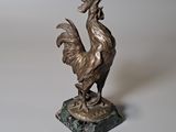 statue d'un coq posée sur un socle en marbre, sur fond blanc