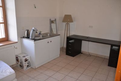 une petite cuisine équipée d'un évier et d'une cuisinière