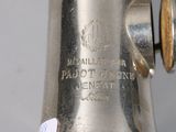 a close up of a silver saxophone with a label on it