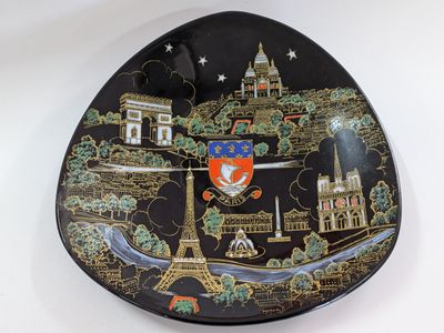 a black plate with a picture of a city on it