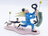 une figurine représentant un homme tenant une clé et un chien