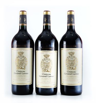 trois bouteilles de vin sont alignées sur une surface blanche