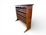 an old wooden bookcase with many books on top of it