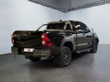 the rear end of a black pickup truck parked in a garage