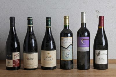 several bottles of wine are lined up on a wooden table