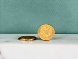 une pièce d'or posée sur un comptoir en marbre
