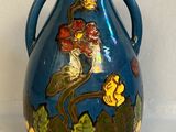 un vase bleu sur lequel sont peints un oiseau et des fleurs