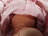 a close up of a doll wearing a pink towel