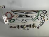 a group of assorted necklaces and bracelets on a table
