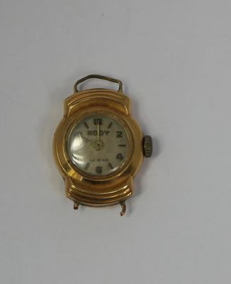 a gold wrist watch with a white face on a white surface