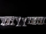 six clear wine glasses are lined up on a black table
