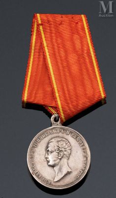 une vieille médaille ornée d'un ruban rouge sur un fond noir