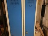 two blue lockers in a room with boxes on the floor