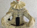 a figurine of a clown sitting on a table