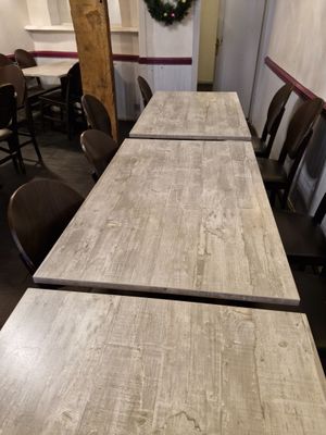 une longue table avec des chaises et une couronne accrochée au mur