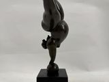 statue of a man doing a handstand on top of a black block
