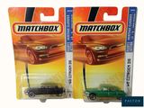 two green matchbox cars are on display on a white background