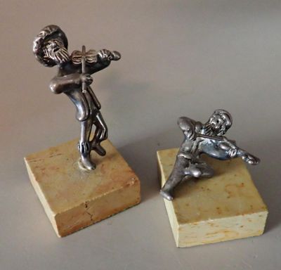 pair of silver figurines of a boy and a girl on a marble base