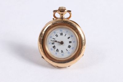 une petite montre de poche en or avec des chiffres romains