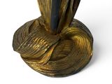 a gold vase with a black handle sitting on a white surface