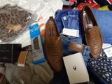 a pile of clothes and shoes on a bed